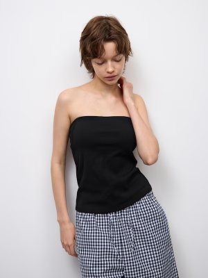Woman modeling a black cropped shirred tube top.