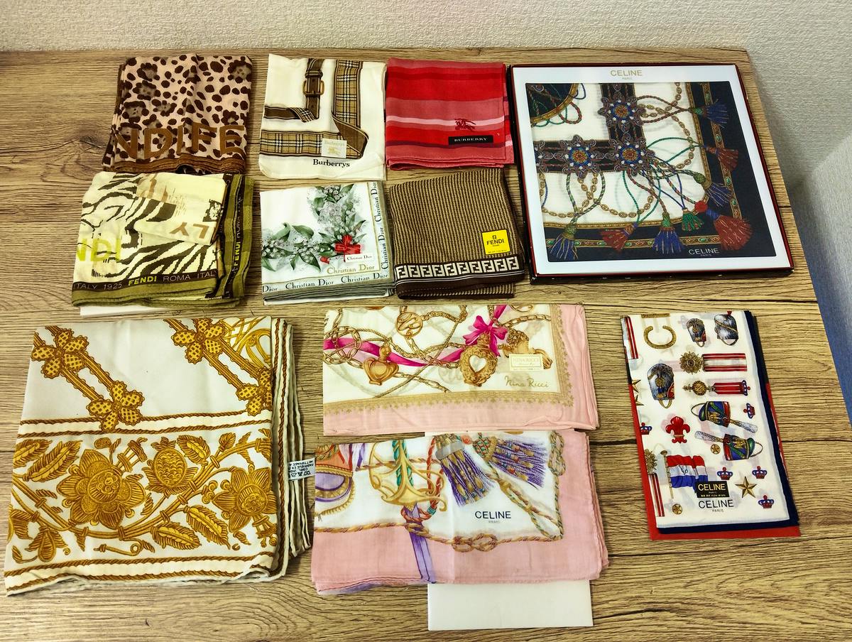A selection of folded branded handkerchiefs and towels laid out on a wooden tabletop.