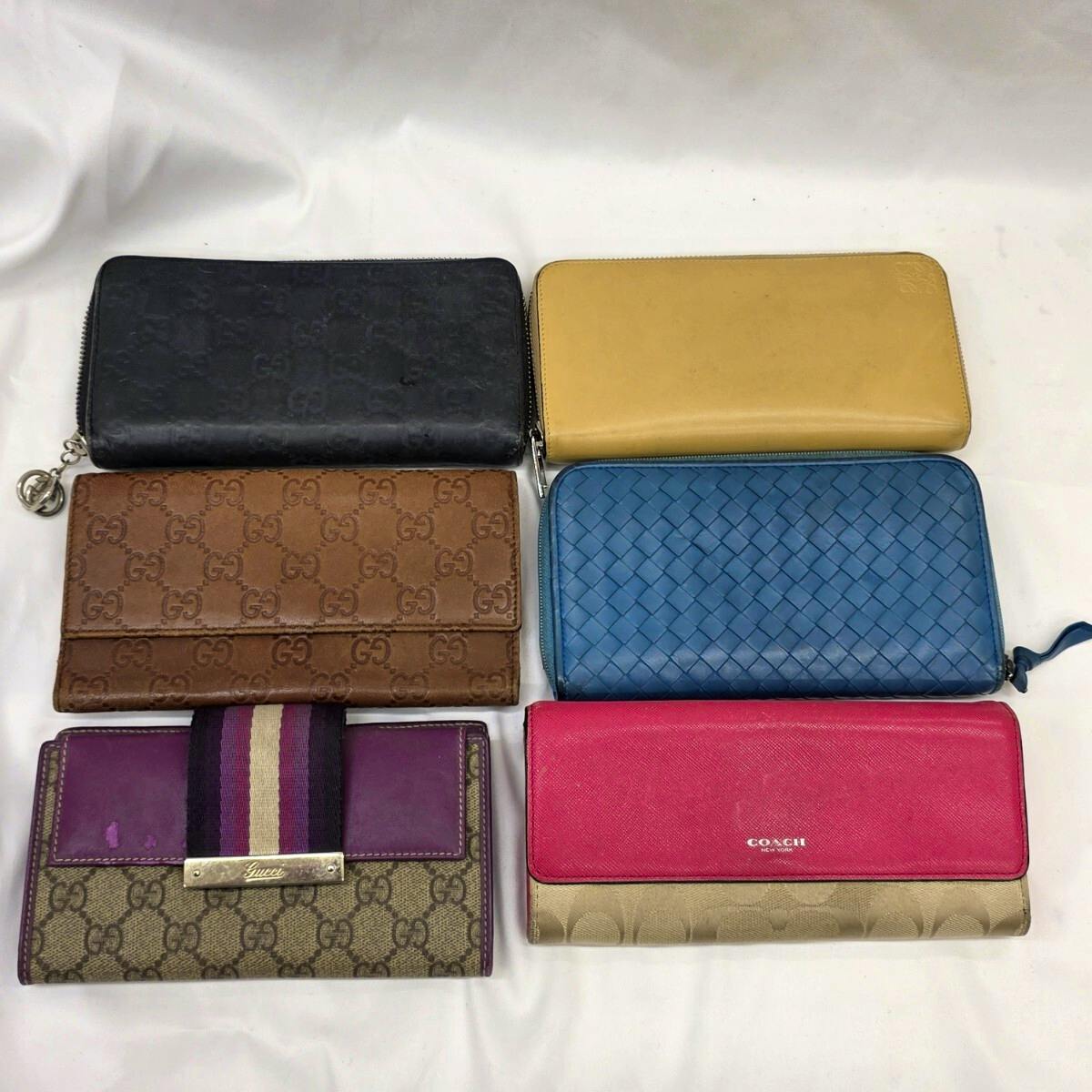 Six wallets arranged on a white background, showing different colors and textures.