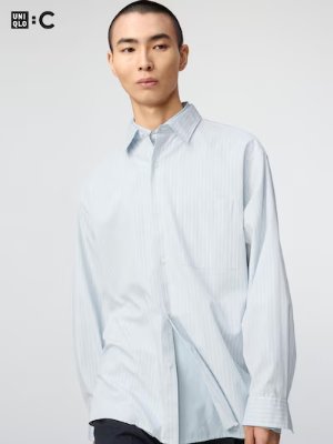 Model wearing a men's oversized cotton shirt with vertical stripes, front view.