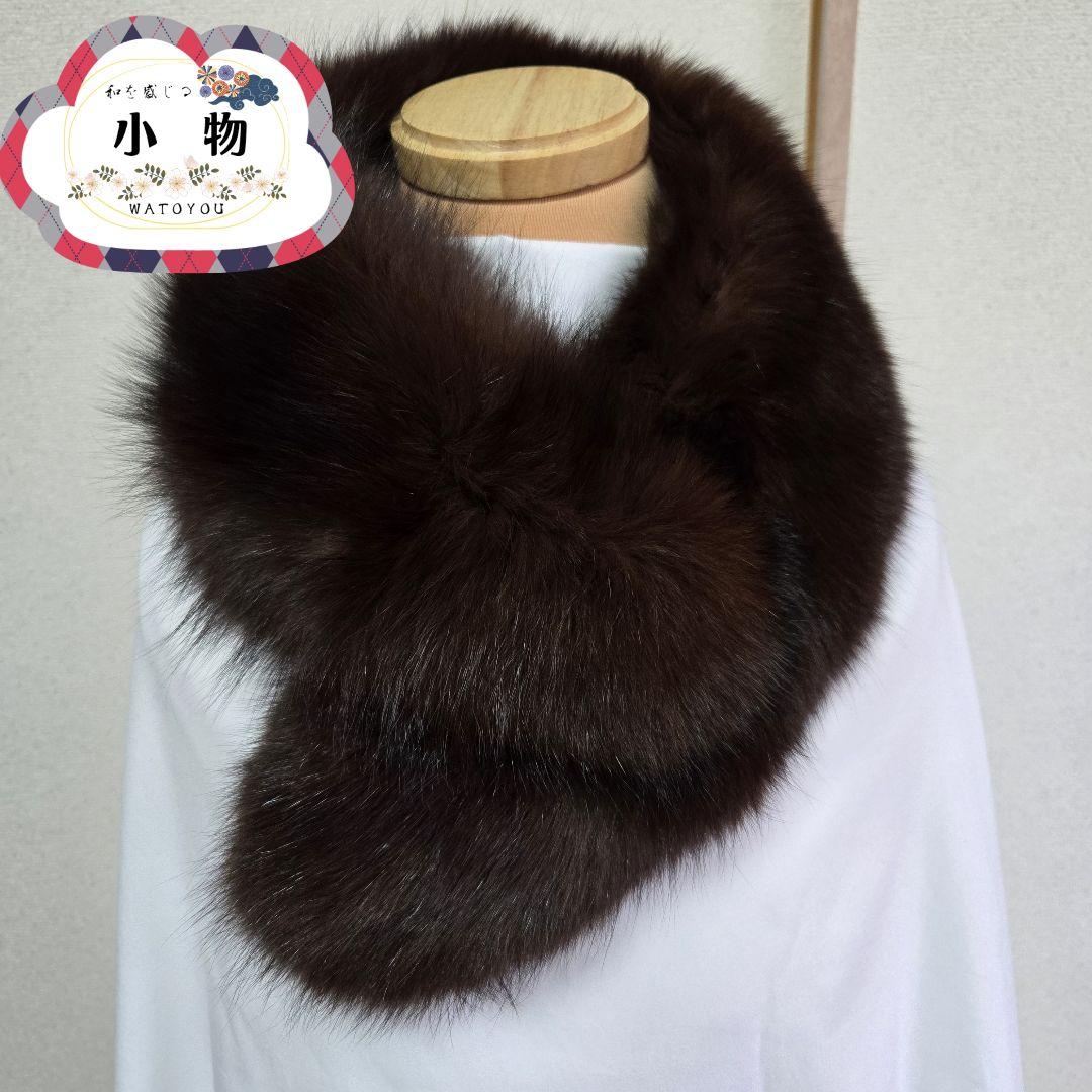 Brown fur scarf/shawl draped around a mannequin over a white cloth.