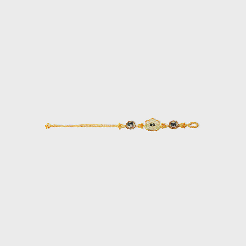 Yellow fabric bracelet (SHOOKY) laid flat on a white background.