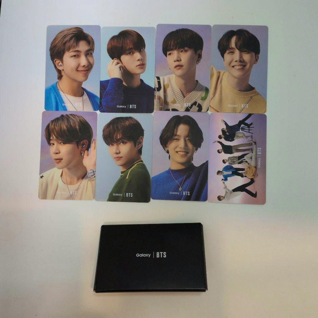 Eight BTS Galaxy photocards arranged above a black Galaxy | BTS card case.