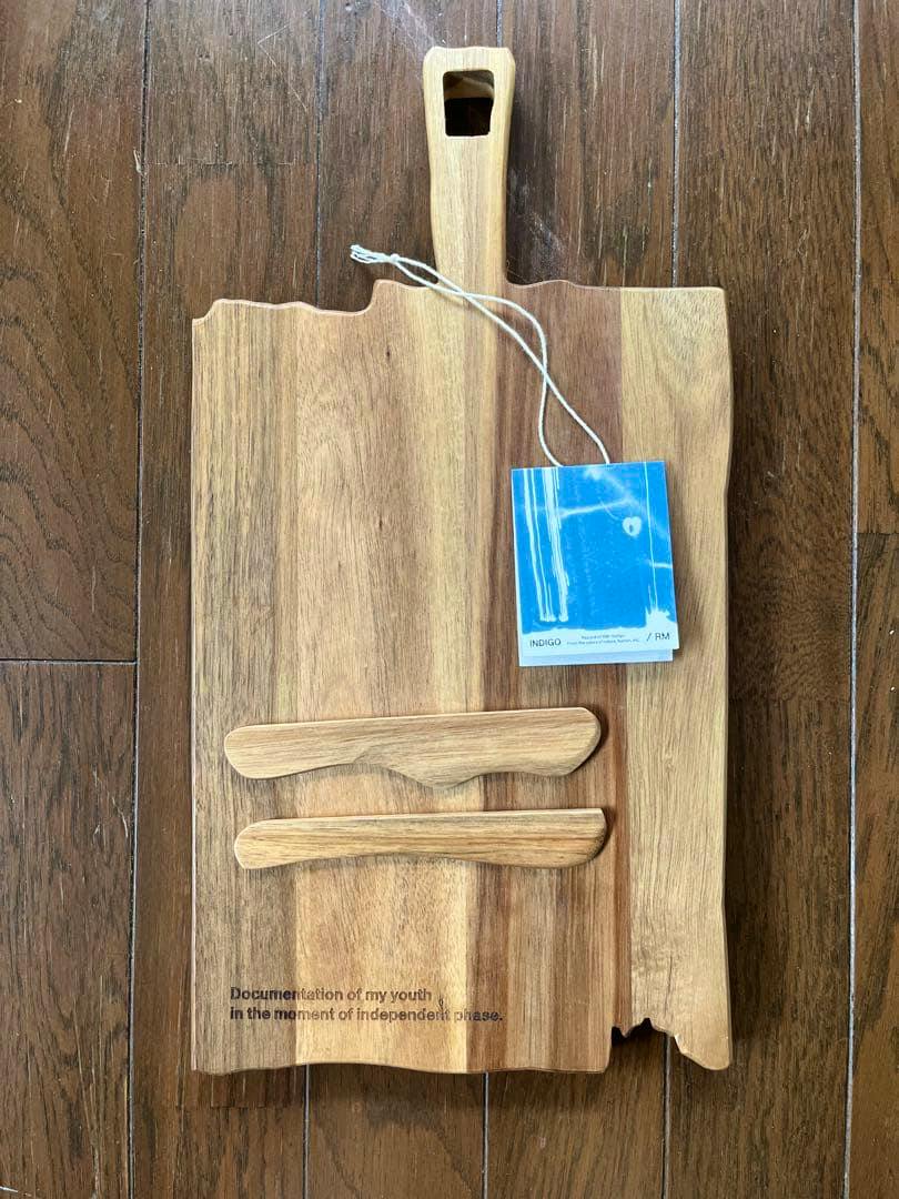 Wood plate set with a handle, two wooden spreaders, and a blue tag on a wooden floor.