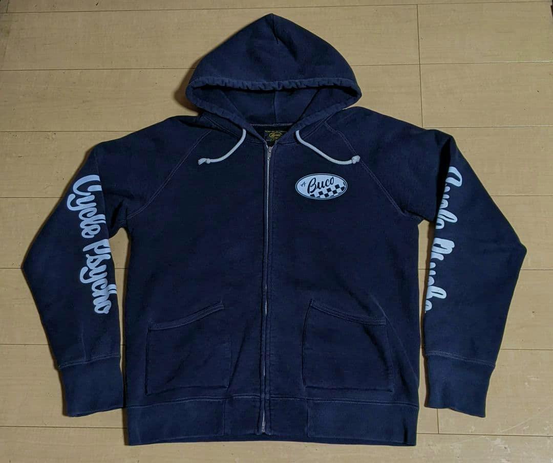Front view of a dark blue BUCO full-zip cotton sweatshirt hoodie laid flat, showing the hood, zipper, kangaroo pockets, and white chest and sleeve graphics.