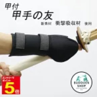 Kendo shock-absorbing forearm supporter (kote attachment) worn on an arm holding a shinai.