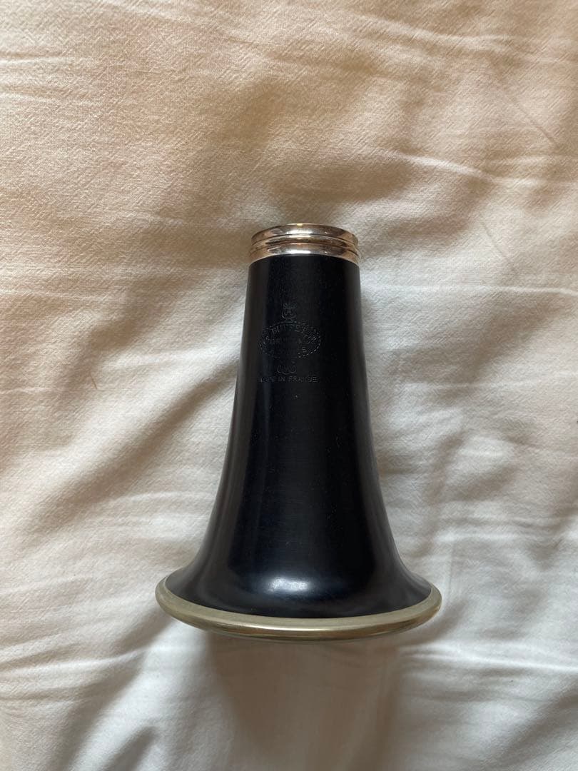 Clarinet bell for a B♭ clarinet shown from the opening, placed on a cloth background.