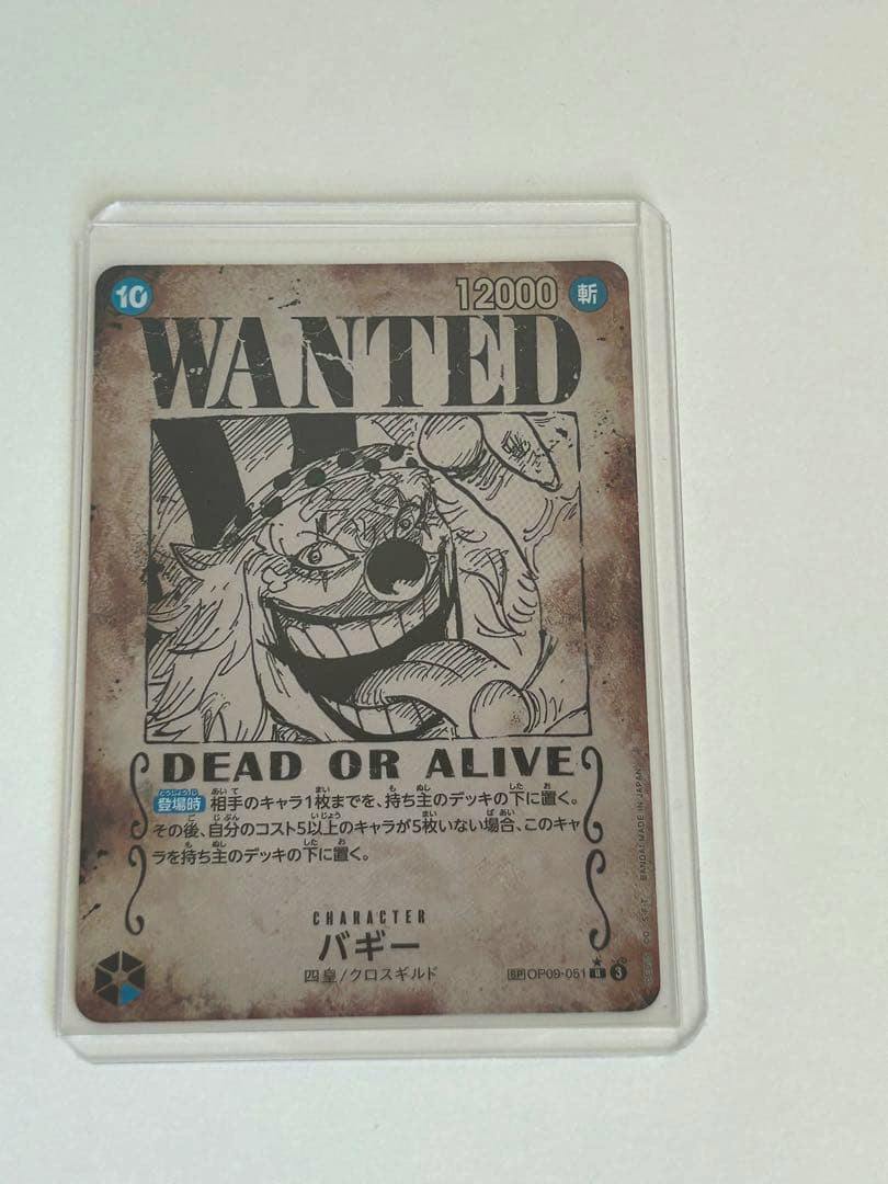 Front of the バギー R SP (OP09-051) trading card in a clear sleeve, showing the 'WANTED' artwork and Japanese text.