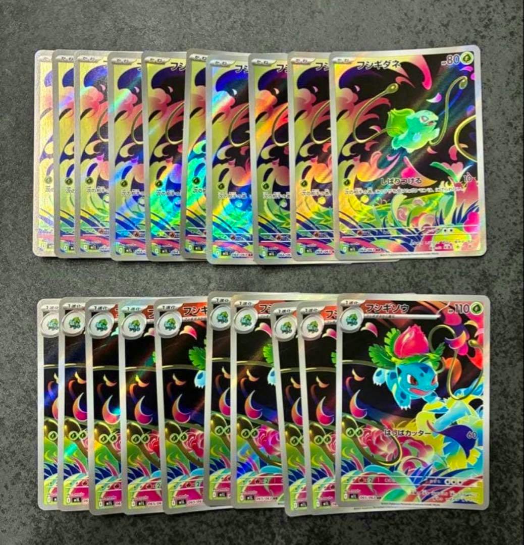 Multiple holographic Bulbasaur (フシギダネ) and Ivysaur (フシギソウ) trading cards arranged in two rows on a dark surface.