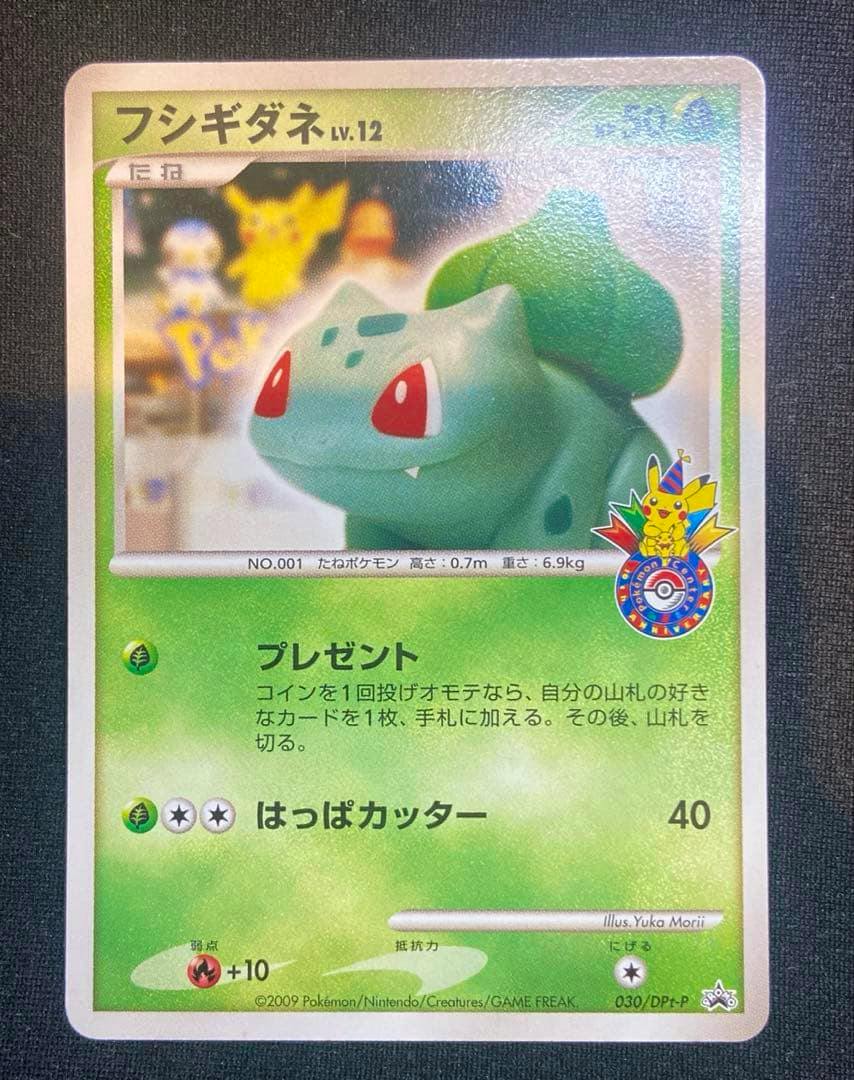 Front photo of the フシギダネ Lv.12 030/DPt‑P promo trading card showing Bulbasaur artwork, Japanese text, and a Pikachu promo logo.