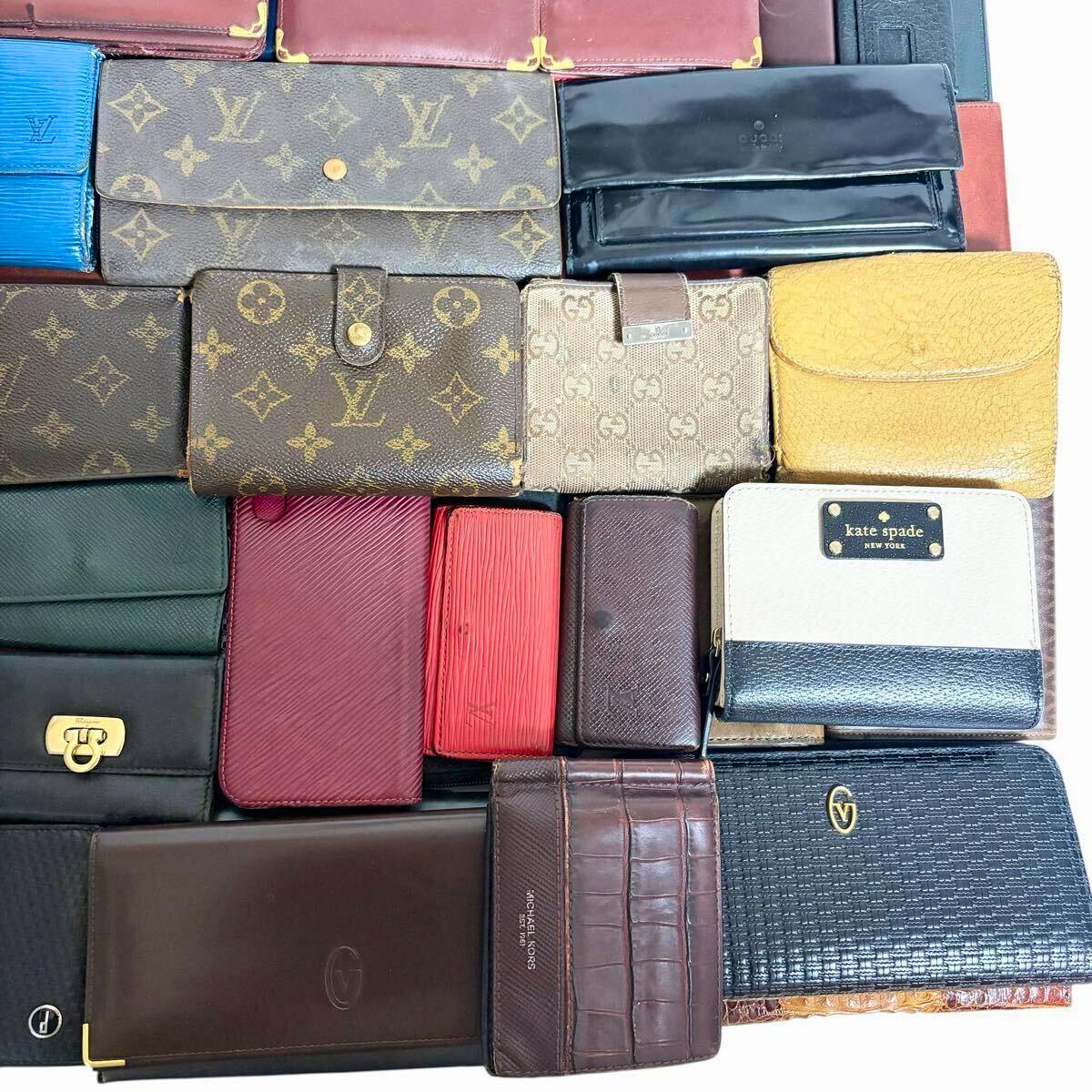 Top-down photo of many assorted wallets and small leather goods arranged closely in a grid, showing various colors and patterns.