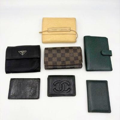 Seven assorted wallets and card/key cases arranged on a white background.