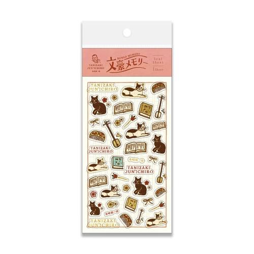 Packaged foil-stamped sticker sheet (Tanizaki Junichiro) showing cats, books, and musical instruments.
