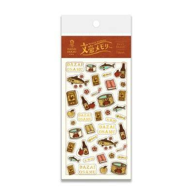 Packaged foil-stamped sticker sheet labeled "Dazai Osamu" showing multiple small illustrated stickers.