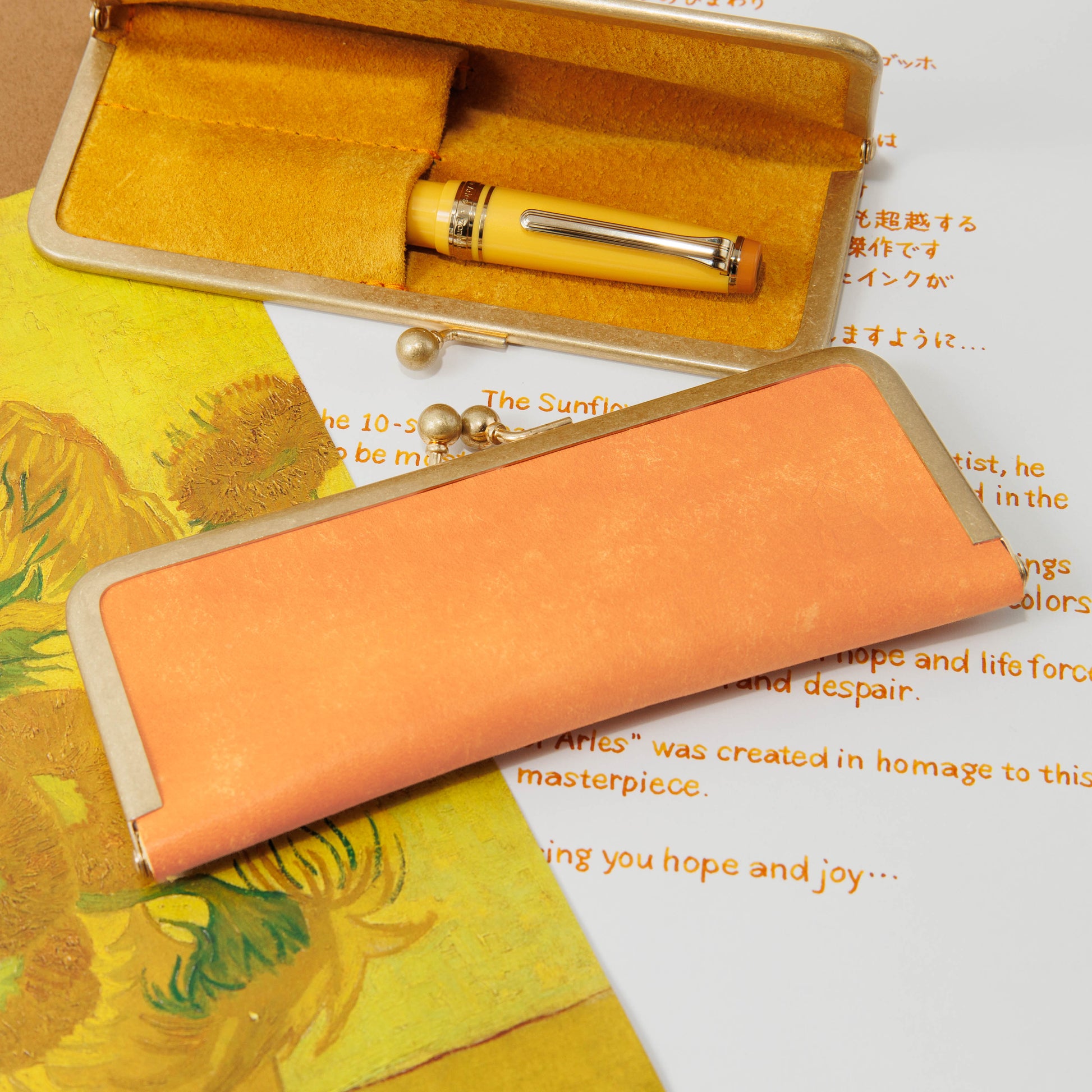 Orange cow leather Sunflowers of Arles pen case for two short pens shown open with one short pen inside and a clasp closure.