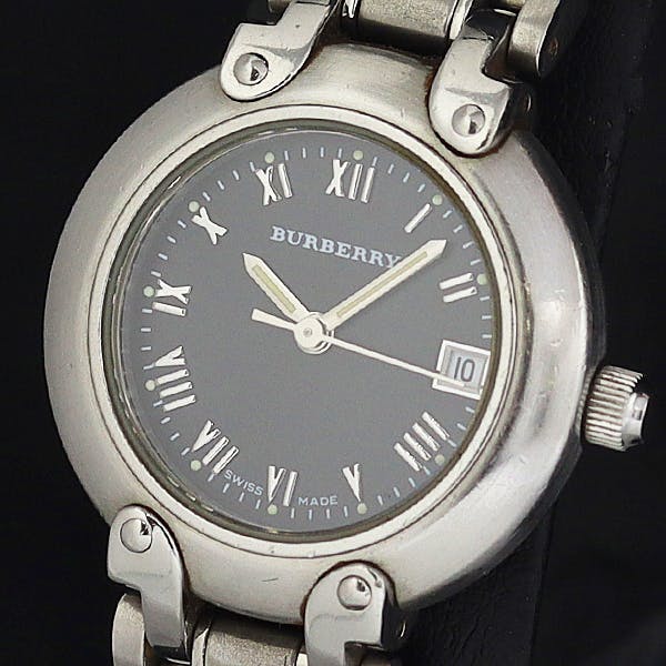 Close-up of the Burberry ladies' quartz wristwatch with black dial, Roman numerals, date window and metal case.