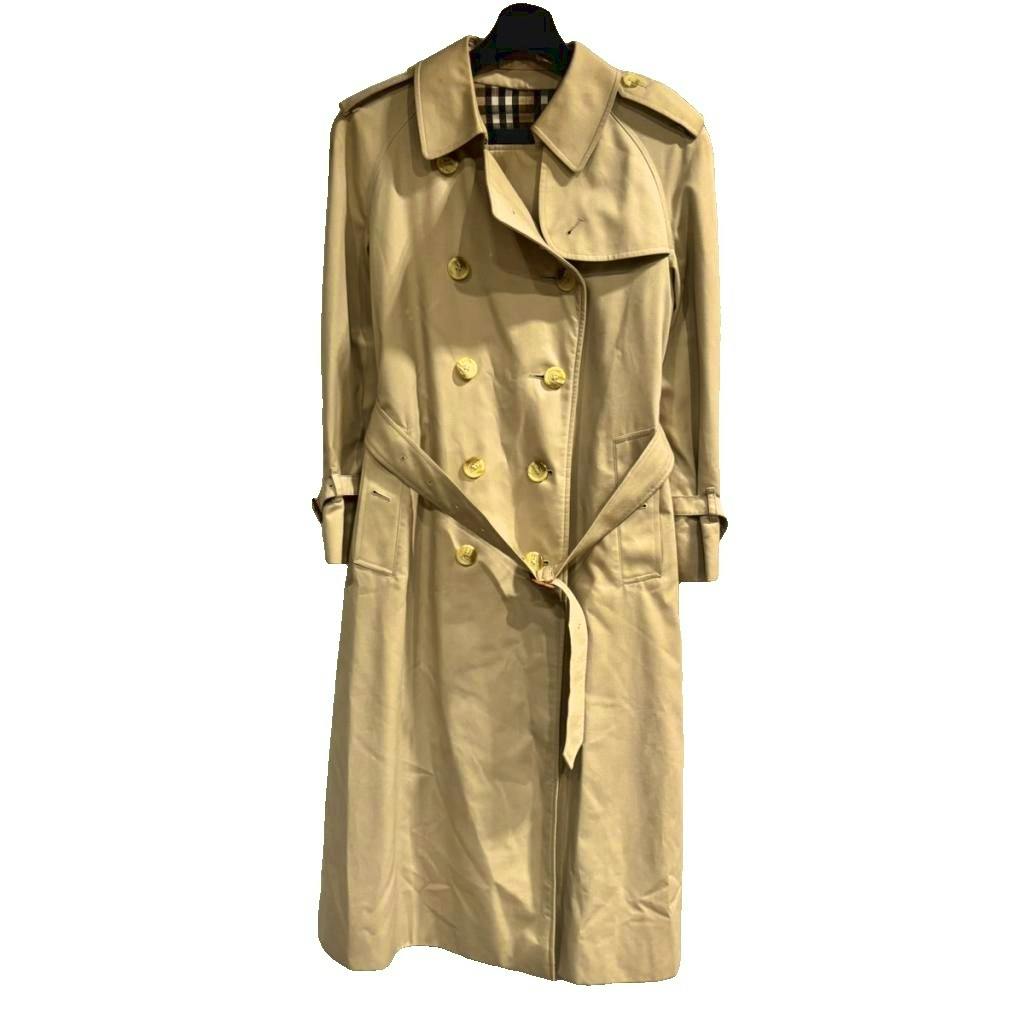 Beige Burberry vintage long trench coat with belt displayed on a hanger showing a bit of Nova Check lining.