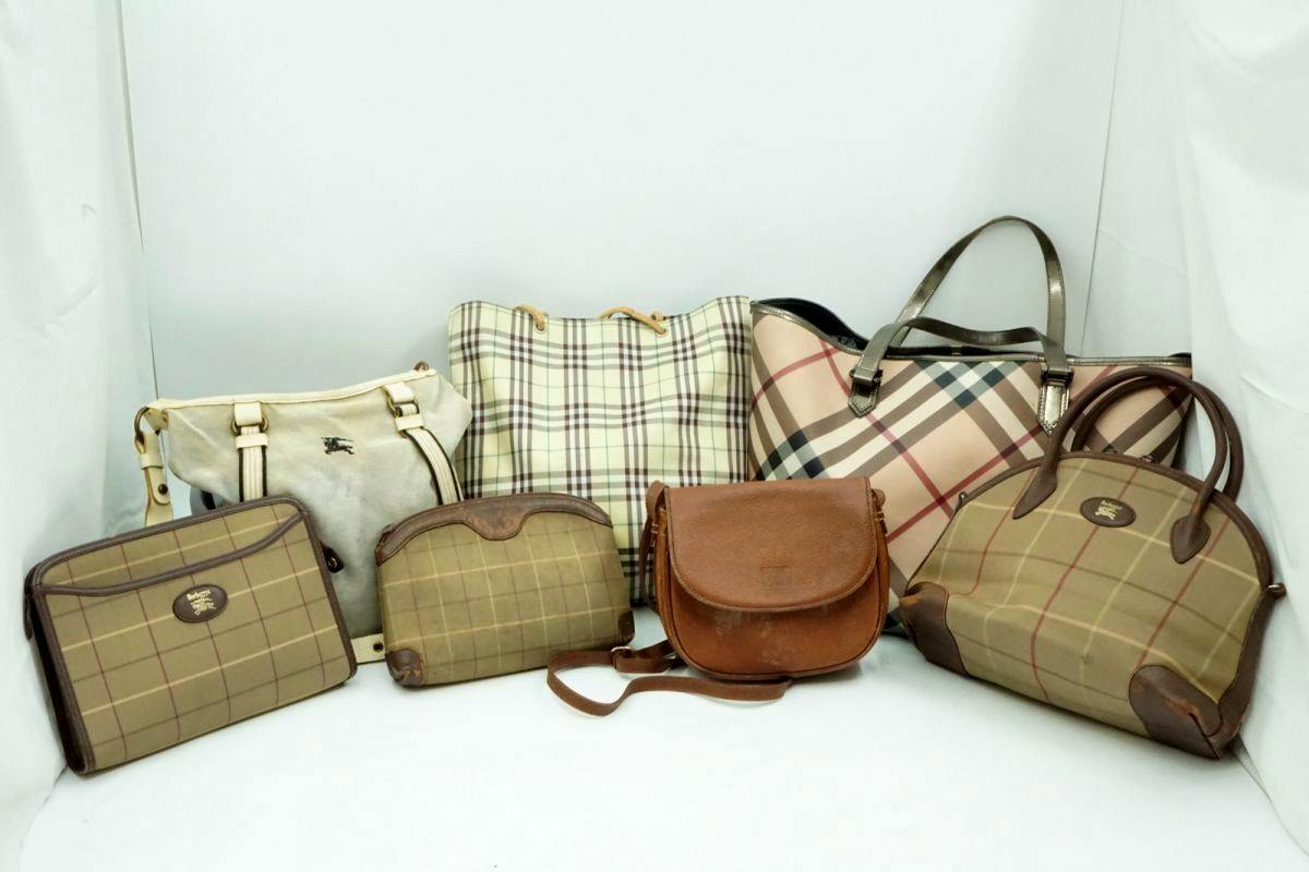 Seven Burberry bags and pouches with various check patterns and leather details arranged on a white background.