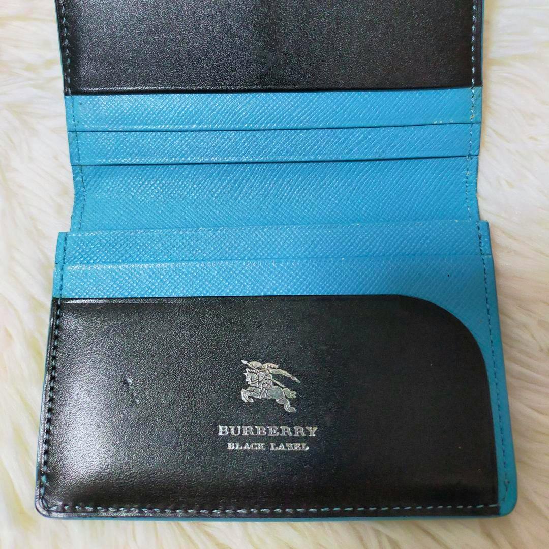 Open Burberry Black Label business card holder showing a black flap and blue textured interior card slots with the Burberry Black Label logo.