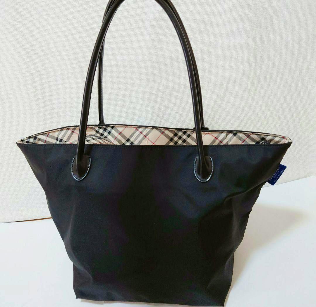 Front view of the BURBERRY BLUE LABEL black tote bag showing Nova Check lining and two top handles.
