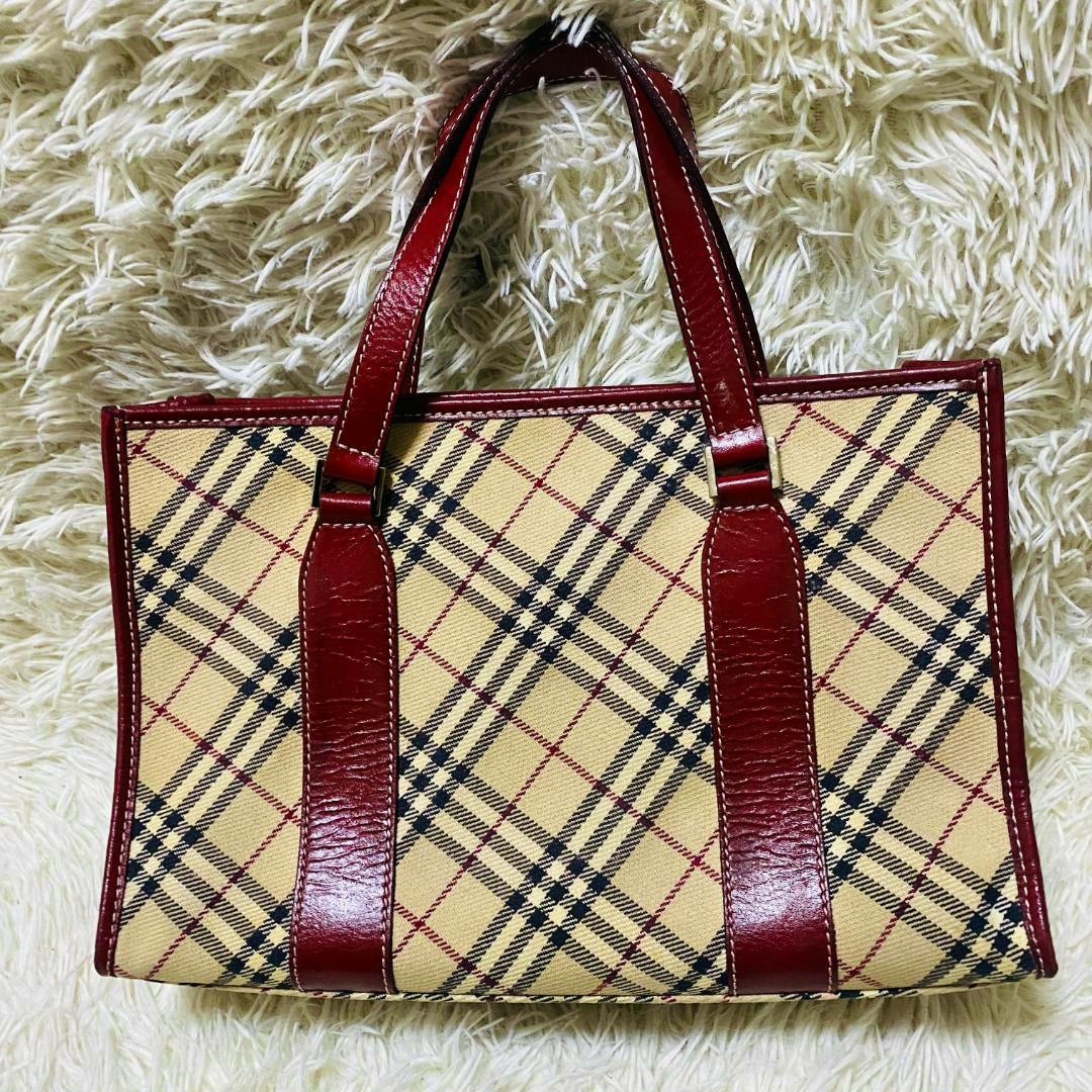 Front view of a BURBERRY BLUE LABEL canvas tote bag in Nova check with red leather trim and handles.