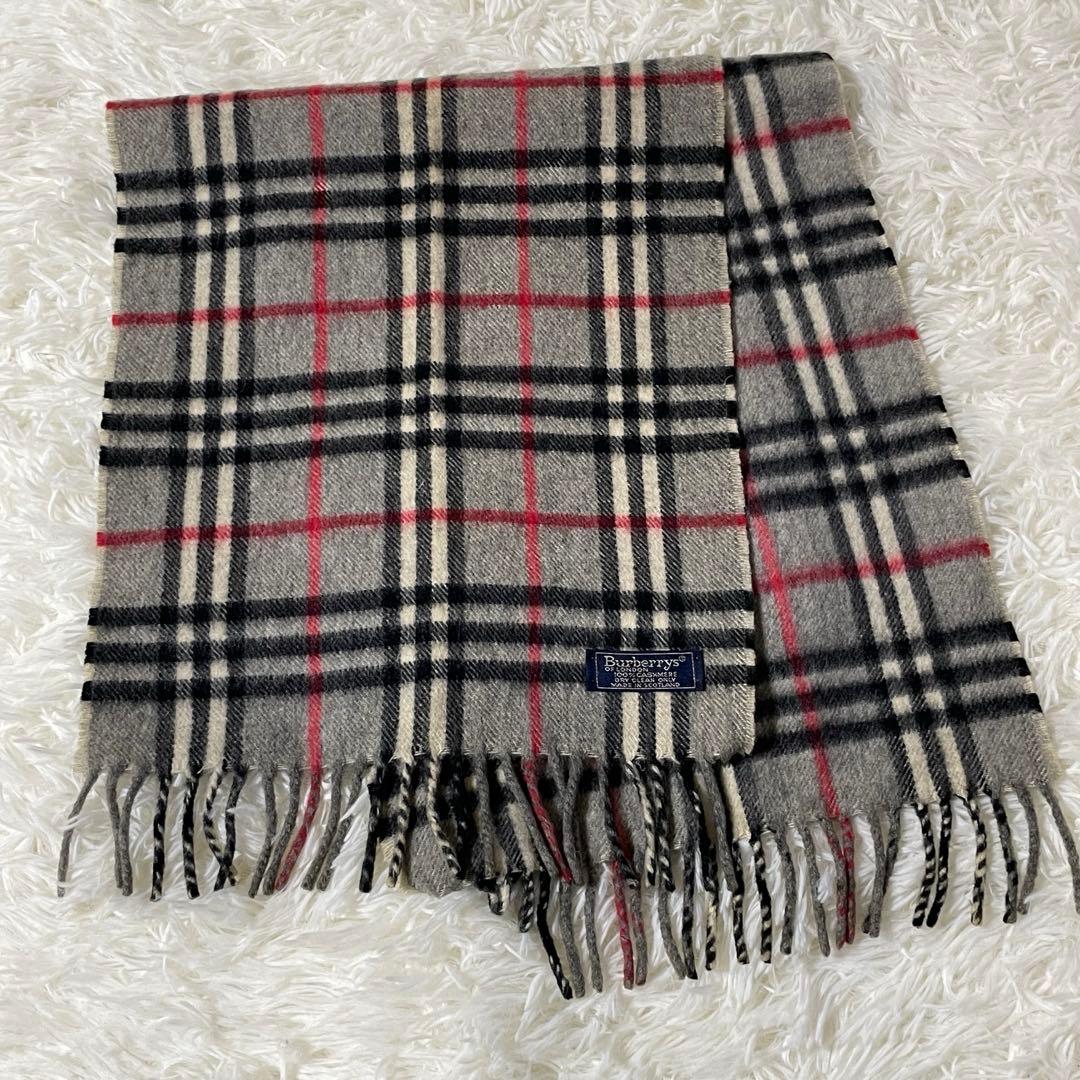 Burberry check-pattern cashmere muffler laid flat on a white background showing fringe and the brand label.