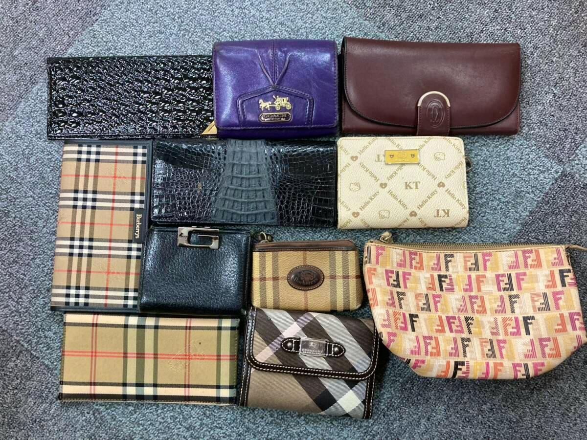 A collection of small wallets and pouches arranged on a carpeted surface.