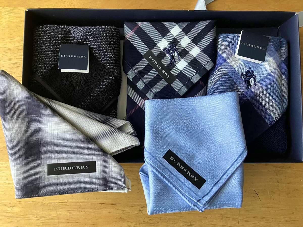 Five folded Burberry cotton handkerchiefs displayed in a gift box on a wooden surface.