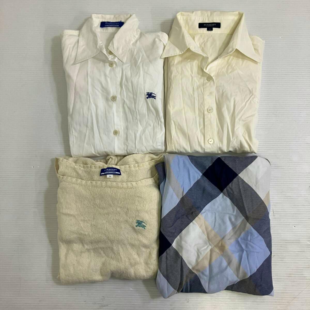 Four folded Burberry garments — two white shirts, a light knit, and a patterned piece — arranged on a flat surface.
