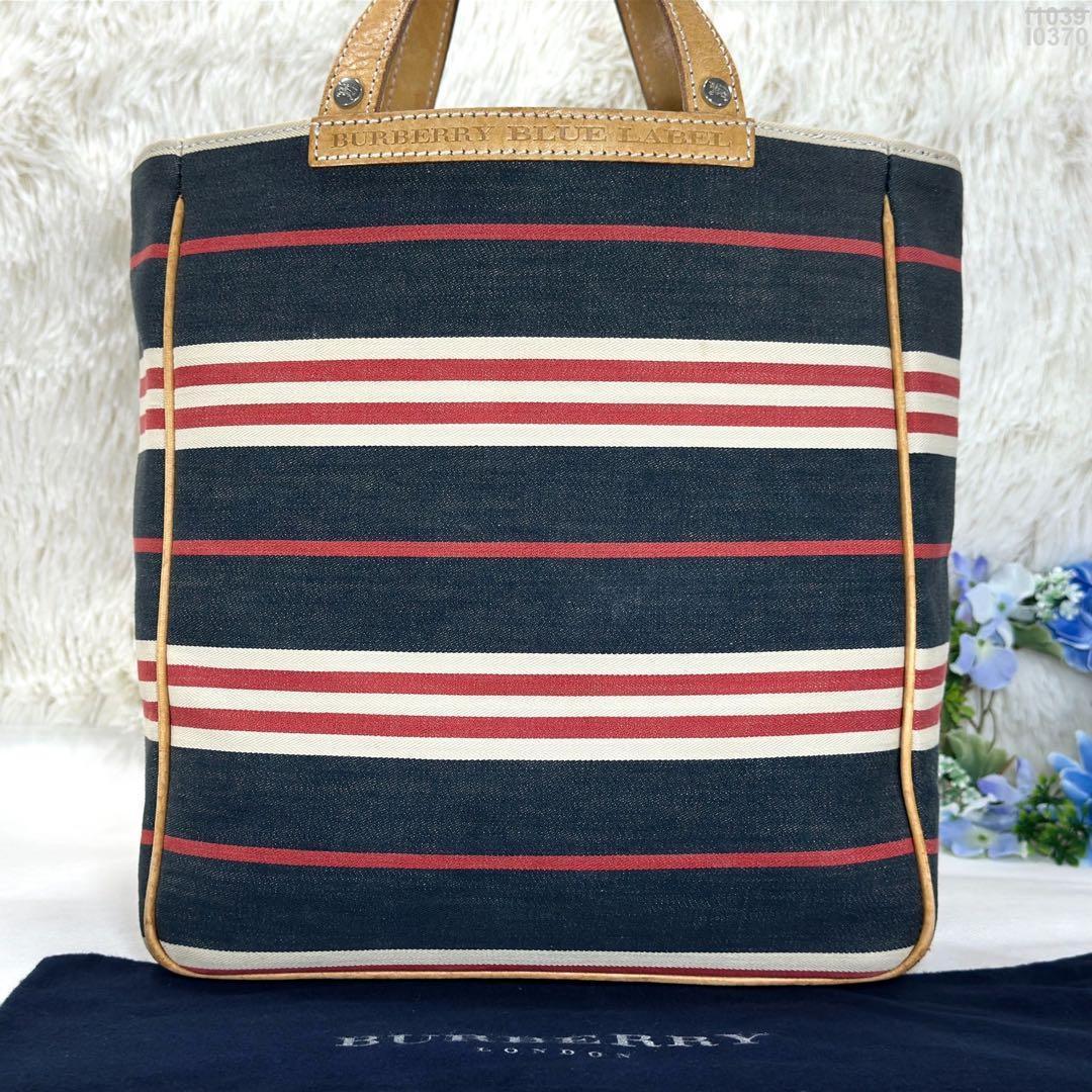 Front view of a striped Burberry London Blue Label tote bag with leather trim and handles.