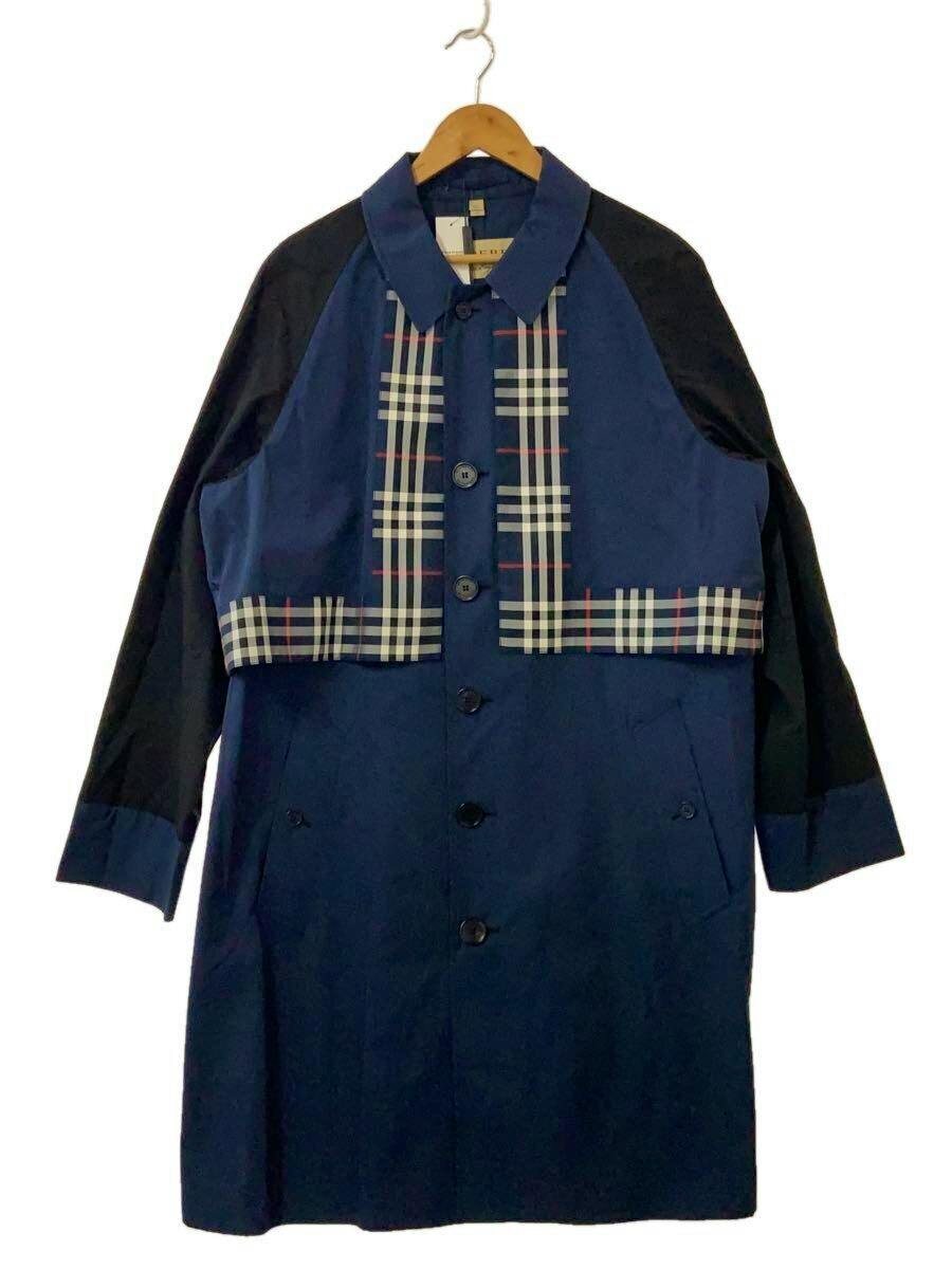 Front view of a navy women's cotton trench coat with black sleeves and check-patterned panels hanging on a wooden hanger.