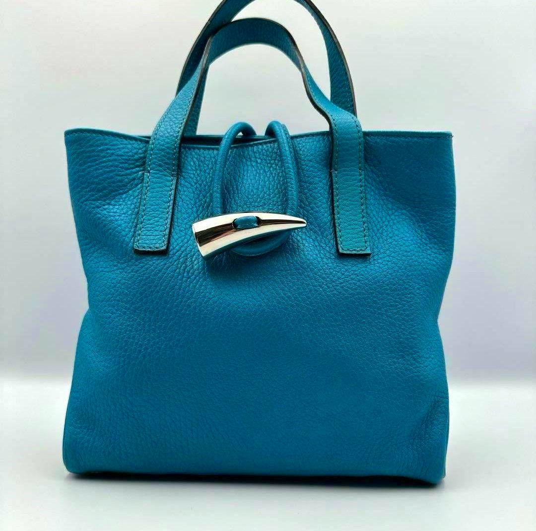 Front view of the teal cow leather Burberry London handbag with short handles and a silver-tone toggle closure.