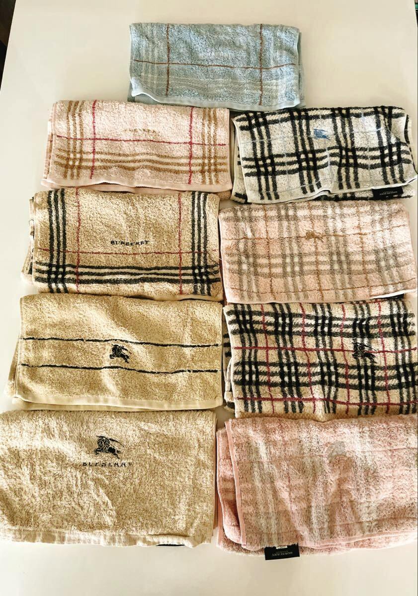 Nine folded Burberry check face towels in pink, beige, blue, and cream arranged on a white background.