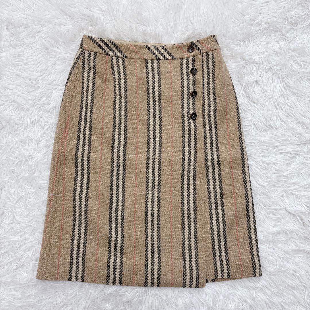 Burberry London nova-stripe wrap tweed skirt laid flat on a white fur background.