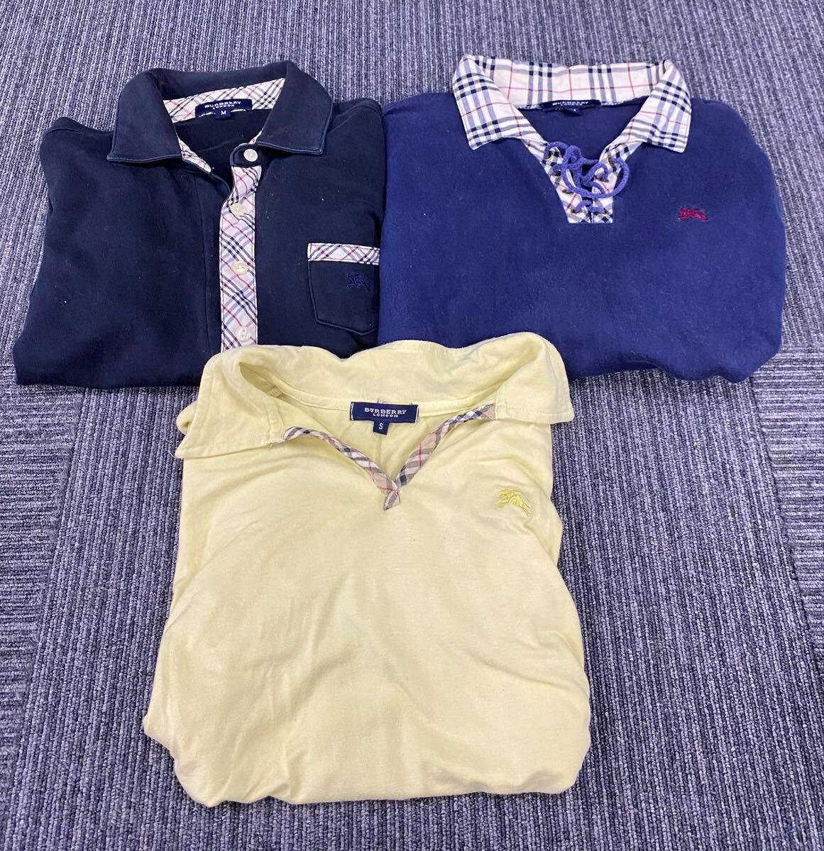 Three folded Burberry tops laid flat on a carpet showing collars and chest areas.