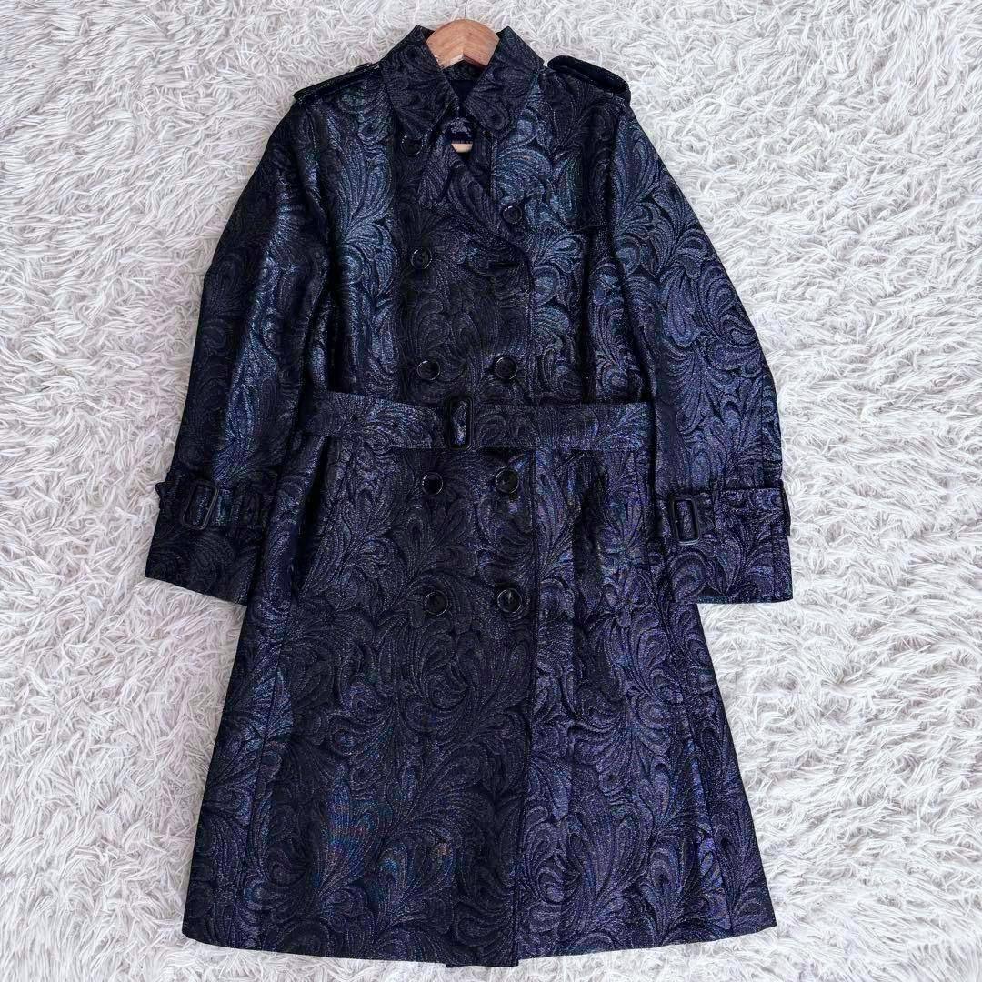 Black paisley-patterned Burberry trench coat laid flat showing its double-breasted front and belt.