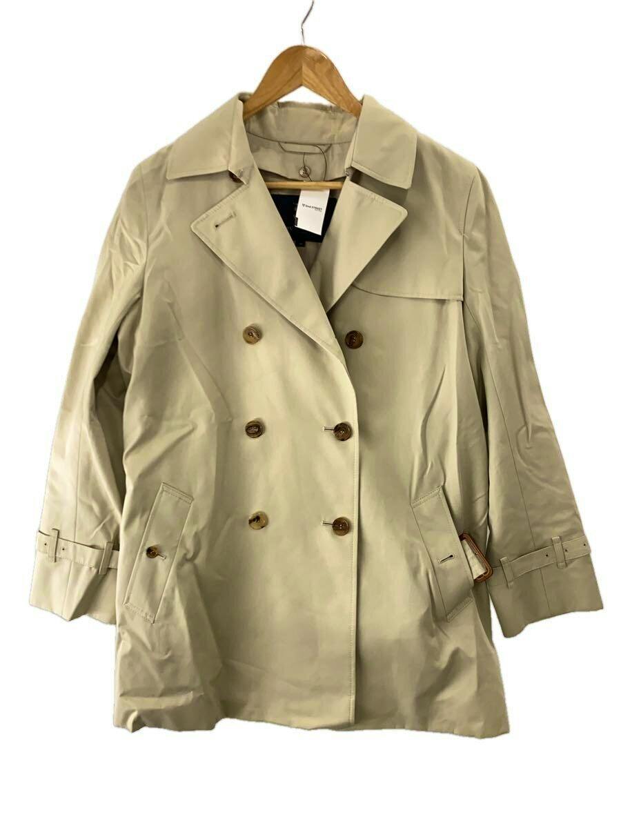 A beige women's cotton Burberry trench coat shown hanging on a wooden hanger.