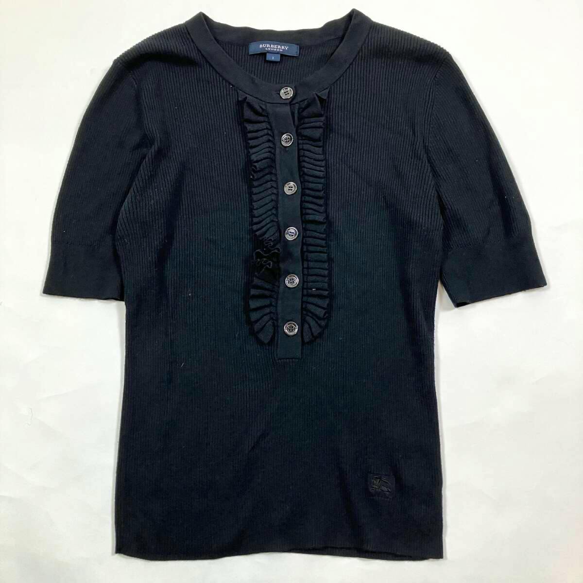 Flat-lay photo of a black Burberry London women's short-sleeve knit top with a half-button ruffled placket and visible label.