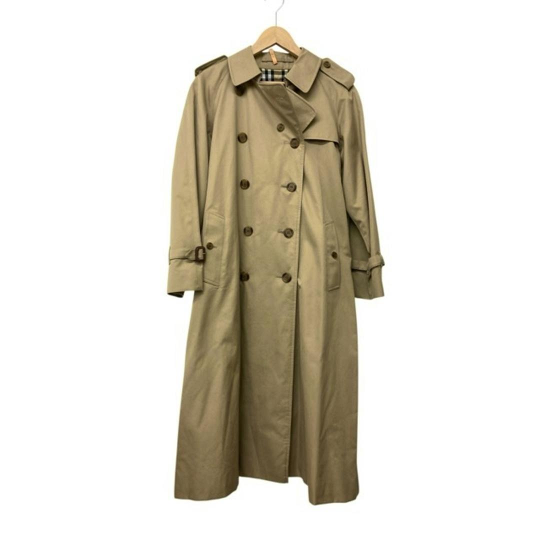 Beige Burberry London women's trench coat hanging on a hanger showing the double-breasted front and visible inner check.