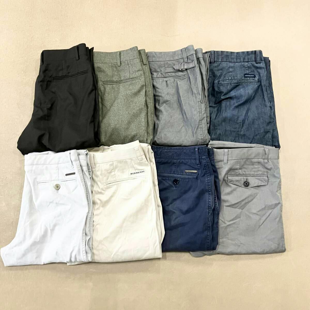 Eight folded men's pants in different colors arranged in two rows, showing back pockets.