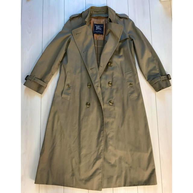 Men's trench coat laid flat showing the front double-breasted design and epaulets.