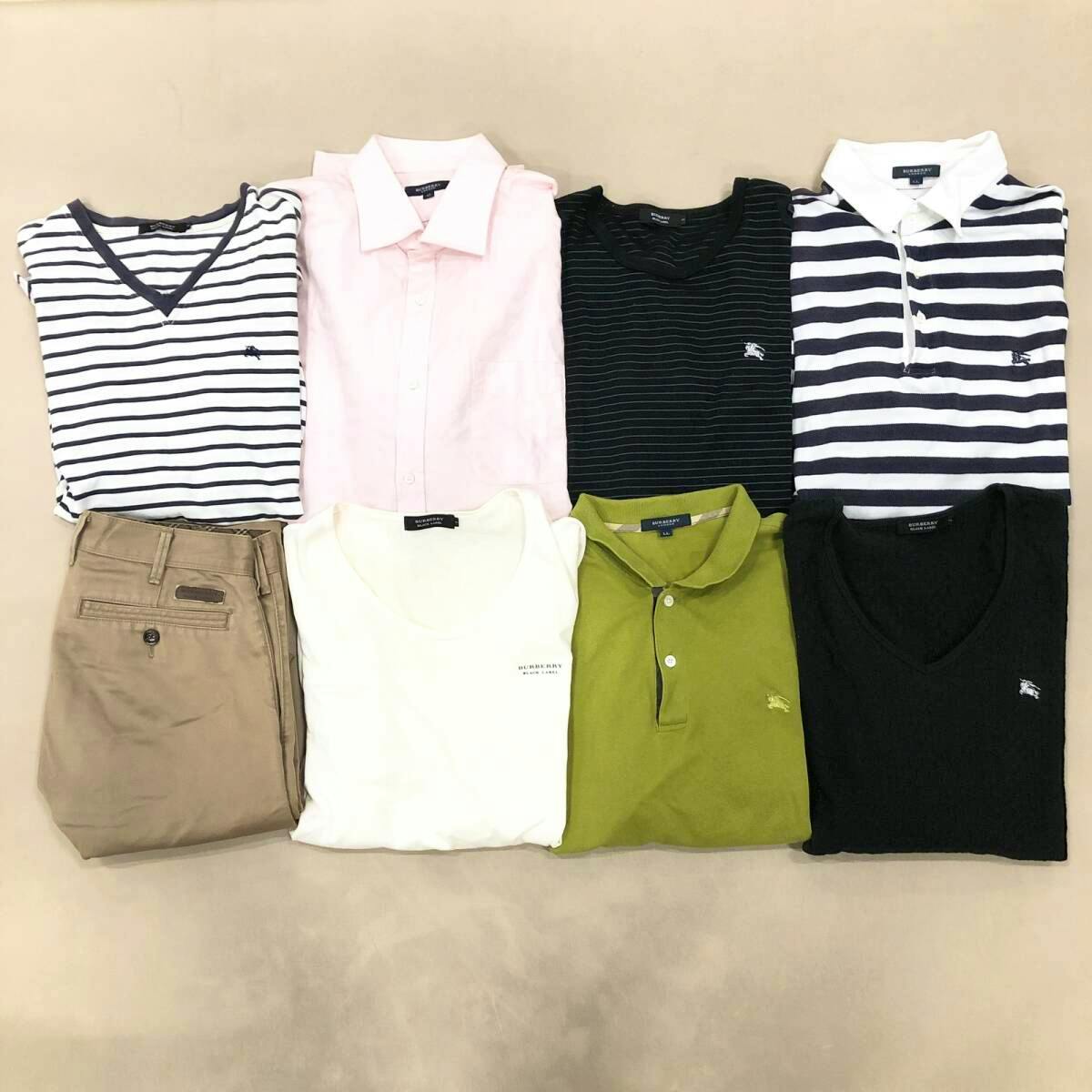 Eight folded Burberry men's tops and a pair of bottoms arranged on a beige surface.