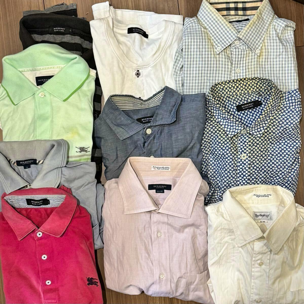 Multiple folded men's Burberry shirts in various colors and patterns arranged on a wooden surface.