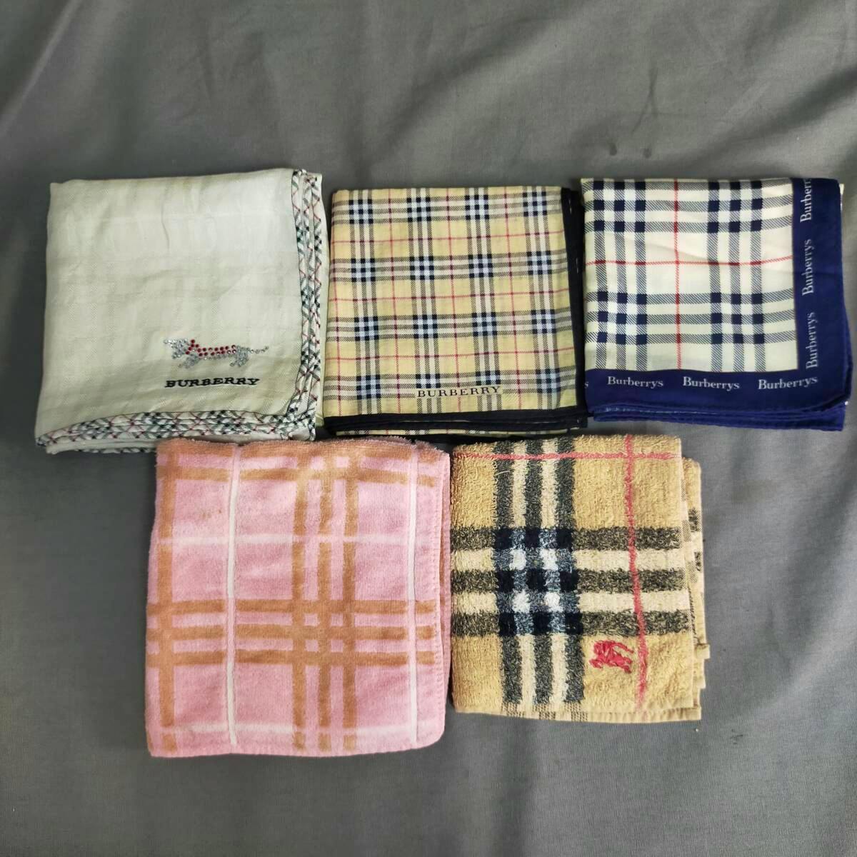 Five folded Burberry hand towels/handkerchiefs in various Nova Check and plain designs arranged on a gray background.