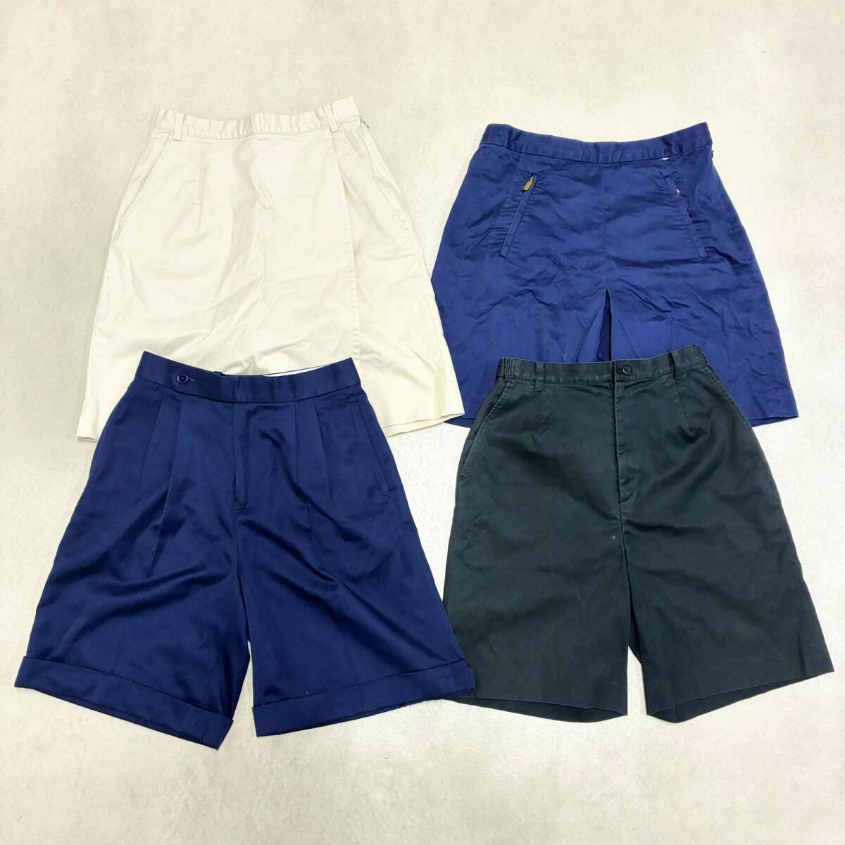 Four garments laid flat on a light background: two skirts (off-white and navy) and two pairs of shorts (navy and black).