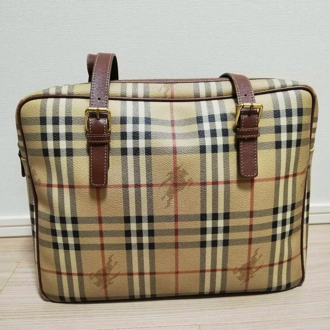 Front view of the Burberry PVC Shadow Horse tote bag showing the beige check pattern and brown straps.