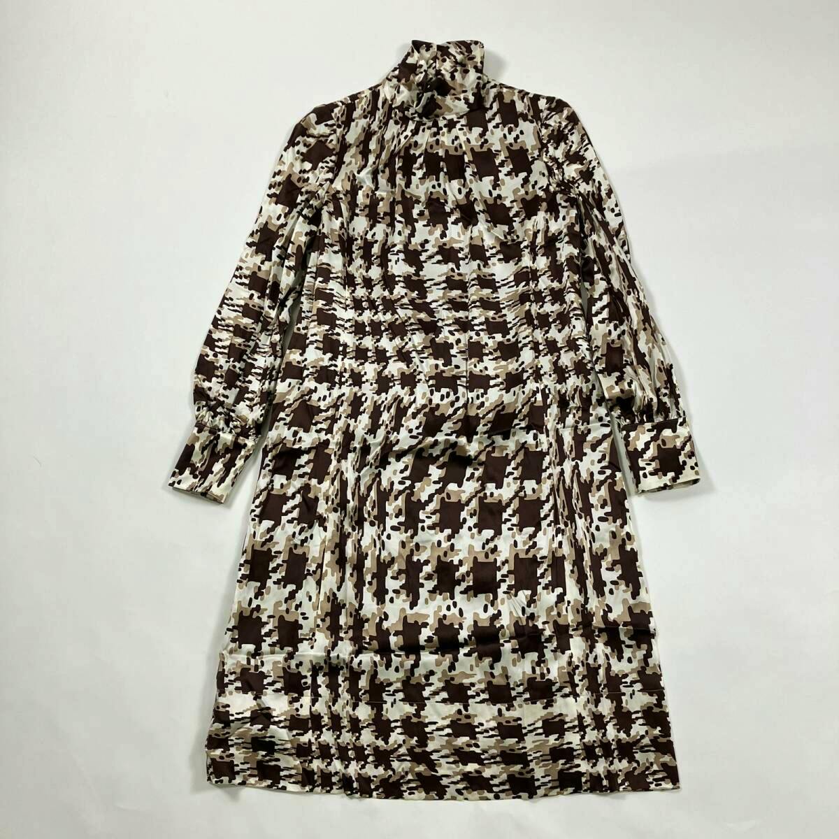 Brown houndstooth-pattern silk high-neck long-sleeve dress laid flat on a white background.