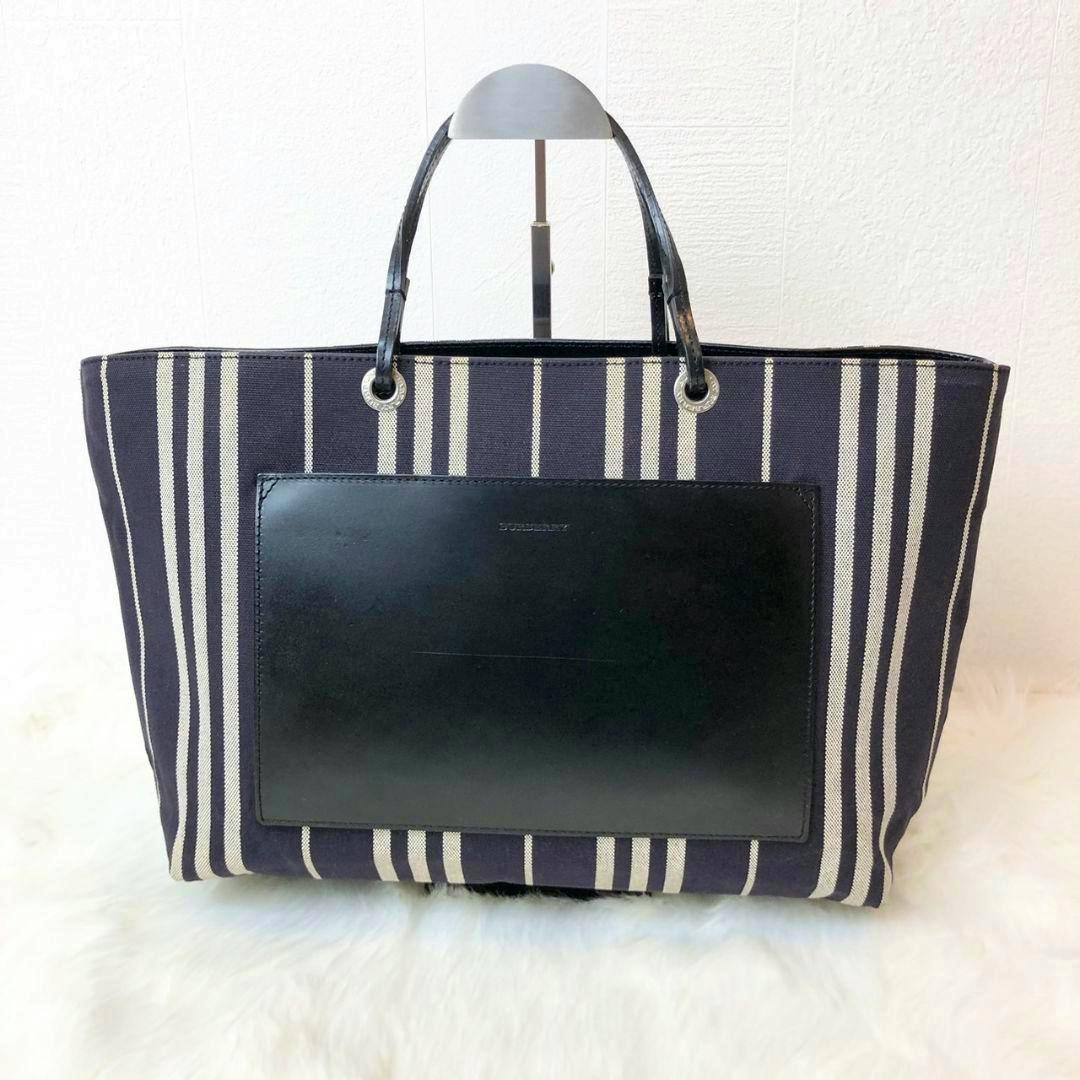 Striped canvas BURBERRY tote bag with a rectangular black leather front pocket and two short leather handles.
