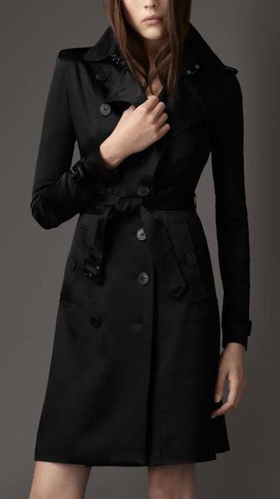 Front view of a model wearing a black women's Burberry silk trench coat.