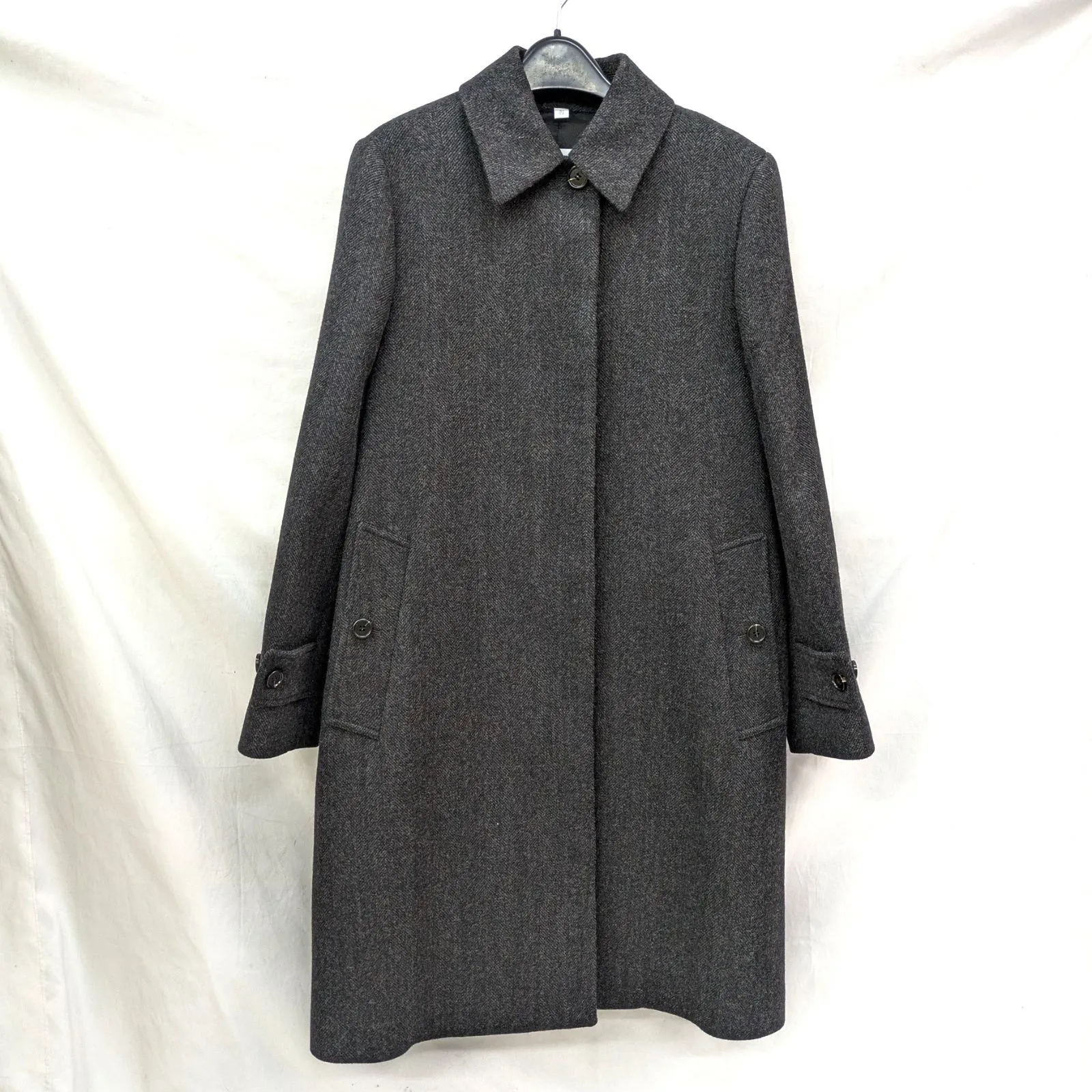 Dark gray Burberry wool long women's coat hanging on a hanger against a white background.